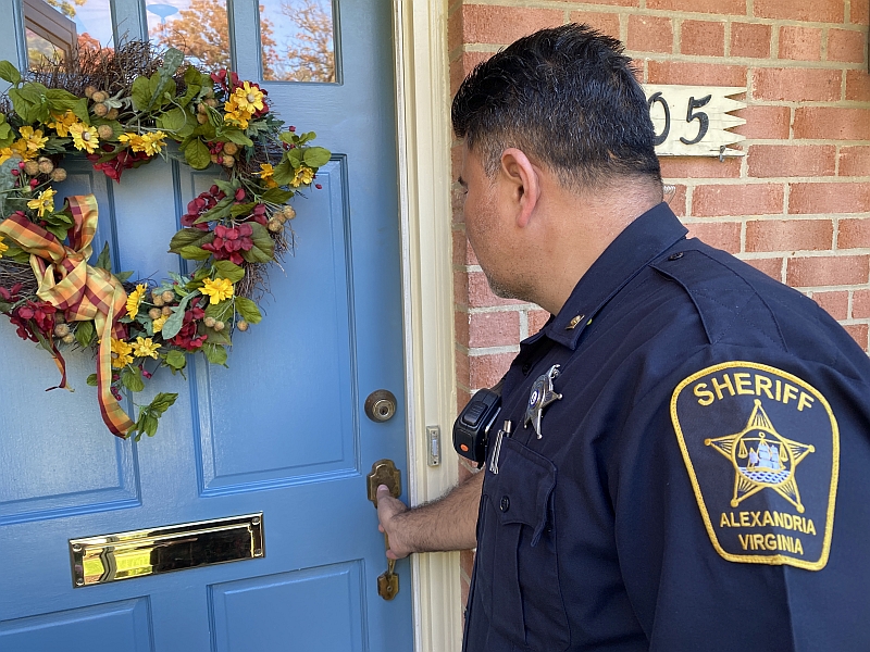 deputy checking door of home