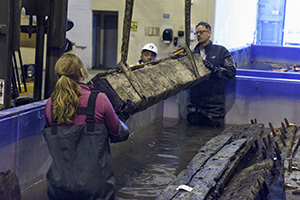 Ship timbers being placed in water in storage tanks. Photo by Anna Frame