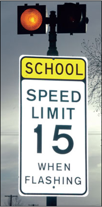  A photo of a school zone flasher sign: flashing lights alert motorists to slow down, sign reads SCHOOL Speed Limit 15 when flashing
