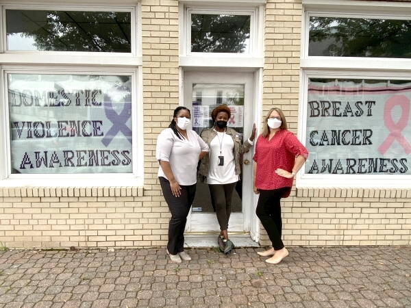 Inmate Services staff outside windows with blankets for domestic violence and breast cancer awareness