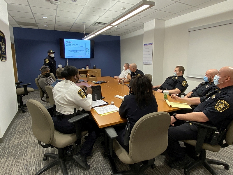 several uniformed deputies at a table listening to a deputy conduct training