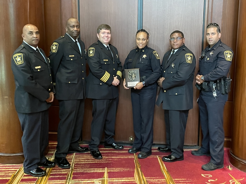 several uniformed deputies with one holding plaque