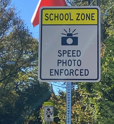 Image showing a sign that reads: "SCHOOL ZONE: Speed Photo Enforced"
