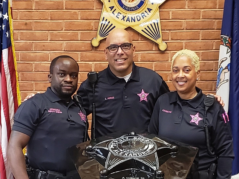 three deputies wearing blue shirts with embroidered pink badges