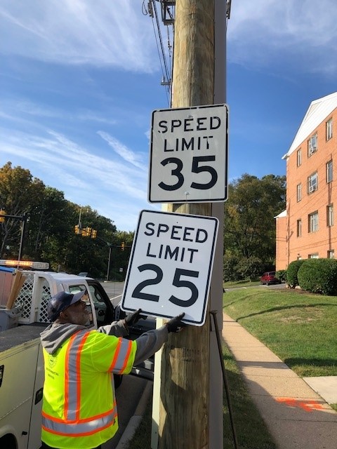 A photo showing a new 25 MPH speed limit sign being installed