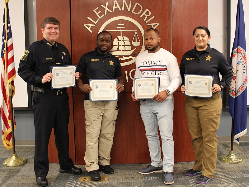 Sheriff and three deputies holding certificates at ceremony