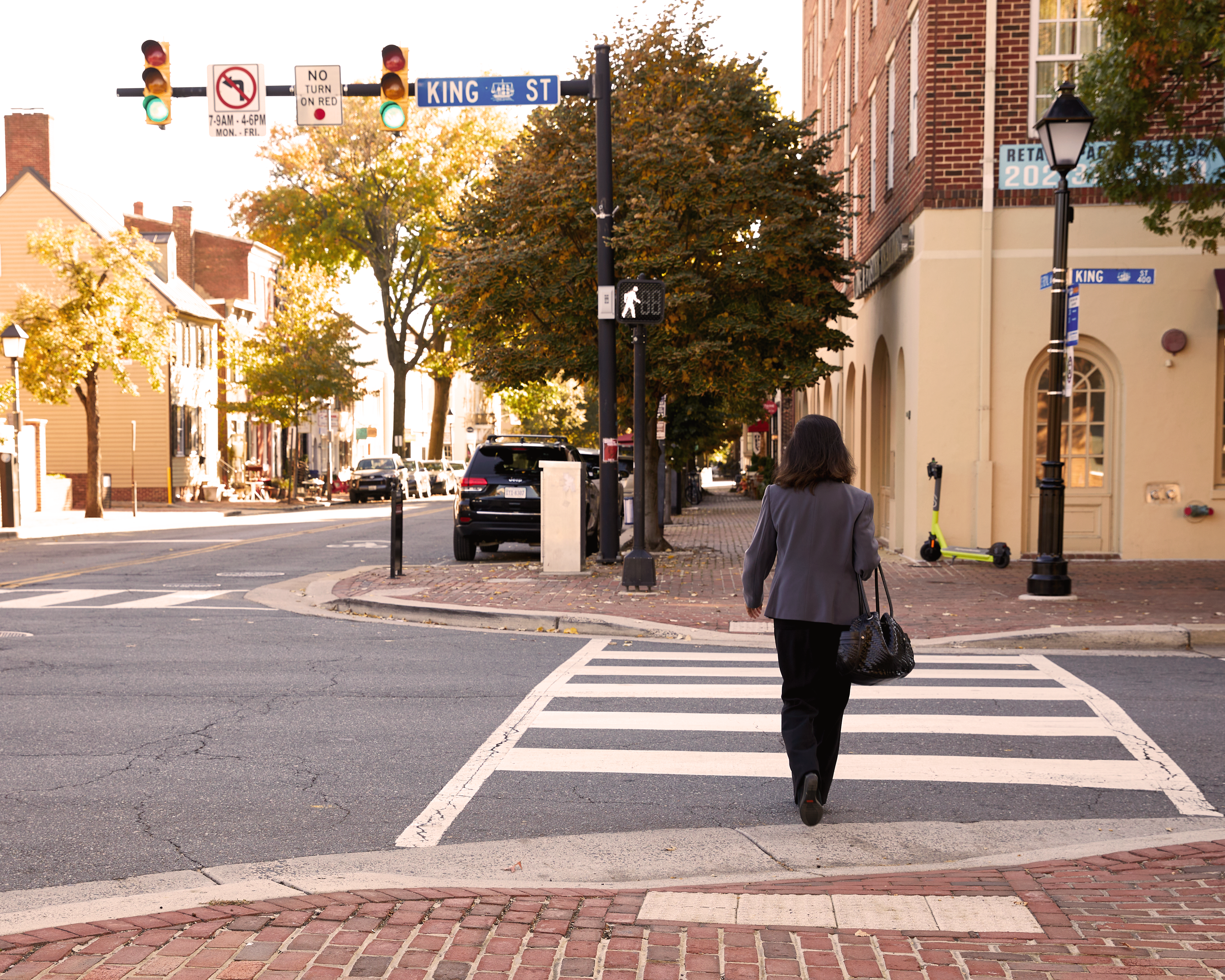 King Street in Old Town Alexandria. A No Turn on Red Sign is posted on traffic signal. Pedestrian in crosswalk