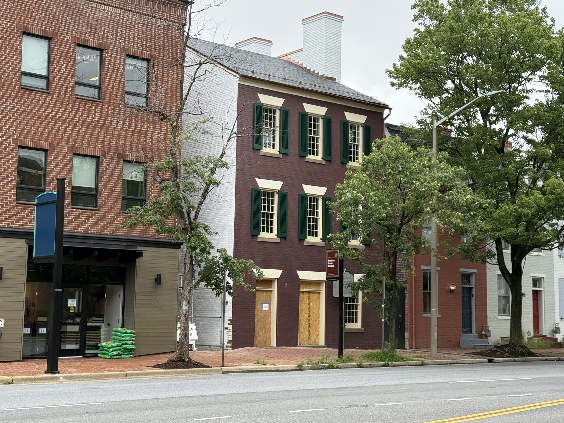 Facade painted dark red, doors boarded up.