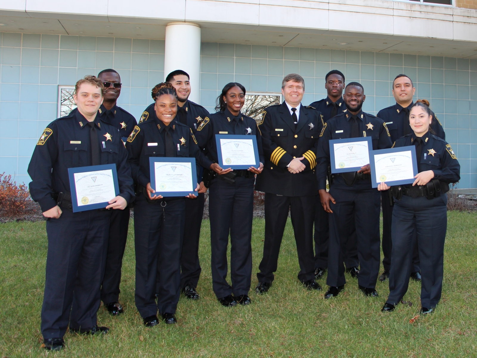 Nine deputies and sheriff, all wearing blue uniforms, standing together and smiling