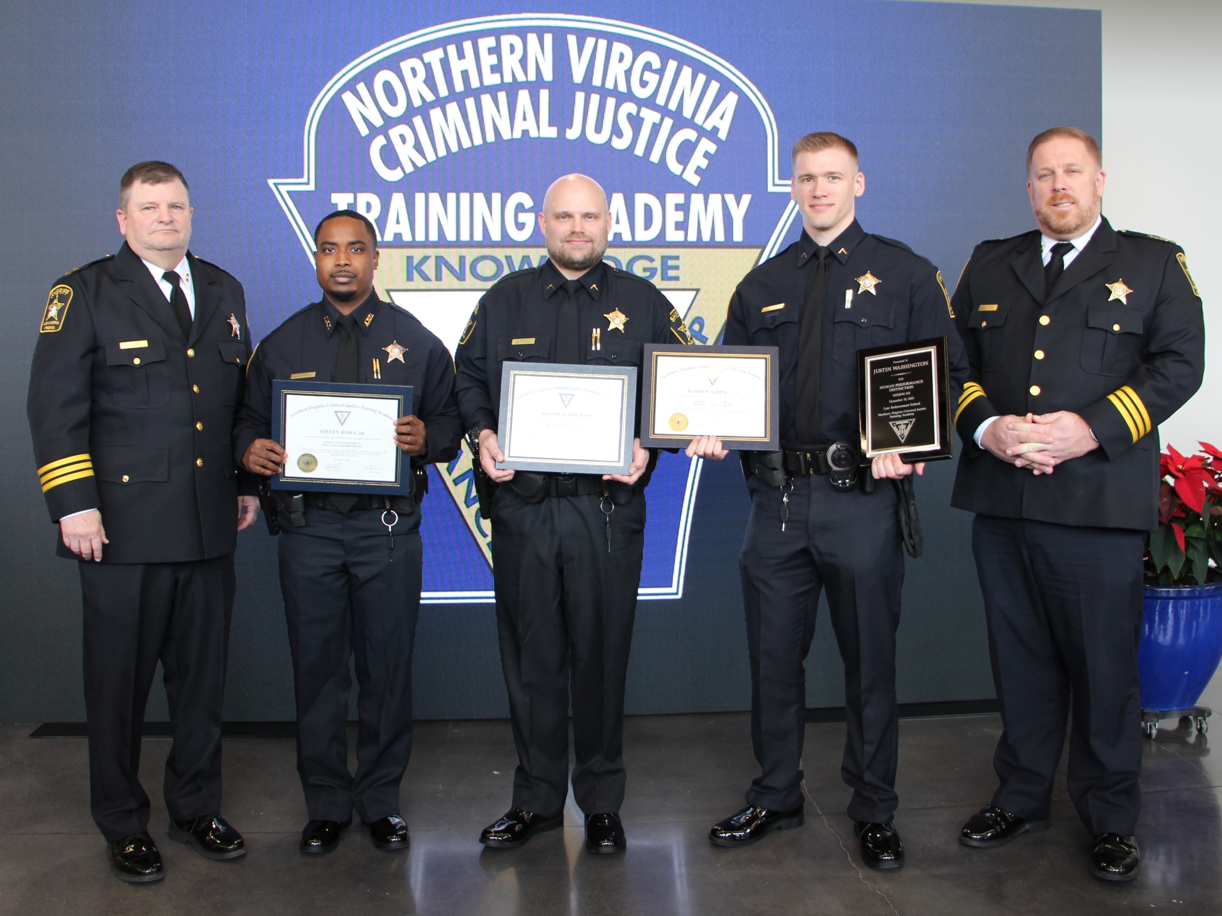 Five deputies wearing blue uniforms and the three in the center holding certificates