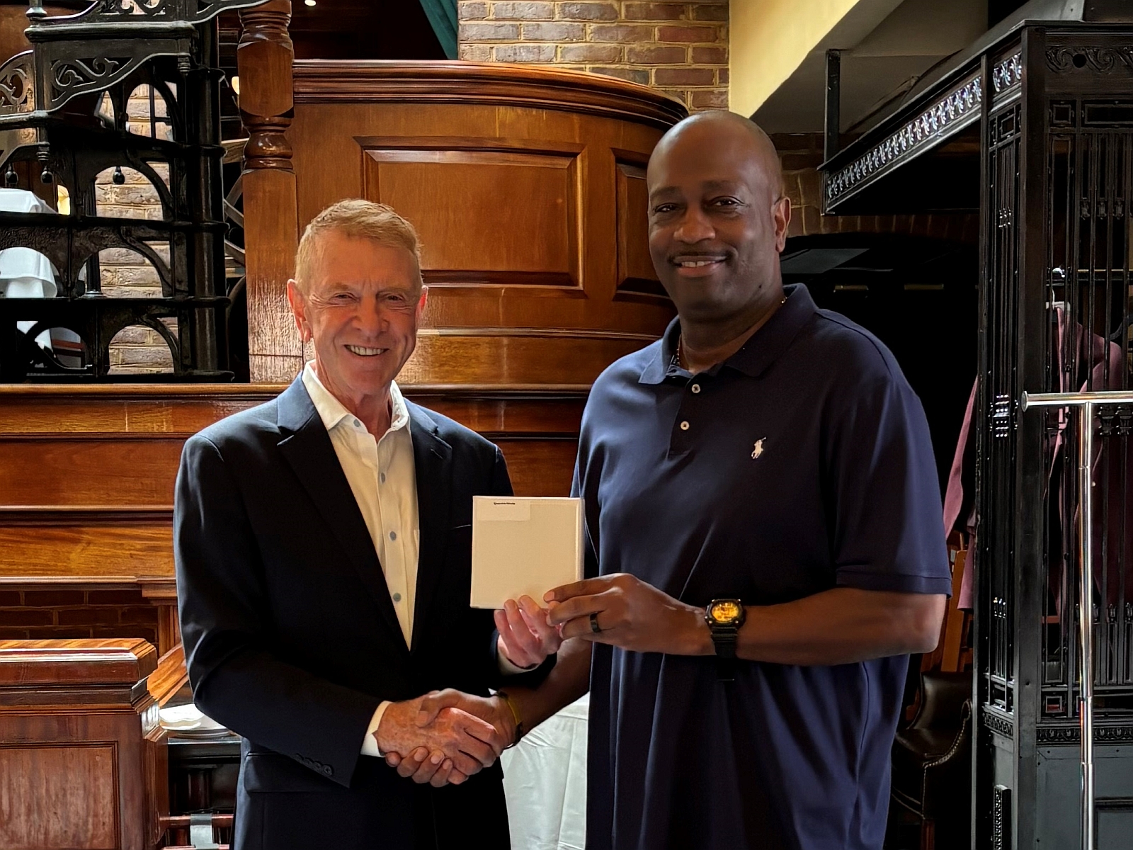 Chamber of Commerce director presenting a plaque to a sheriff's commander who is in civilian clothing