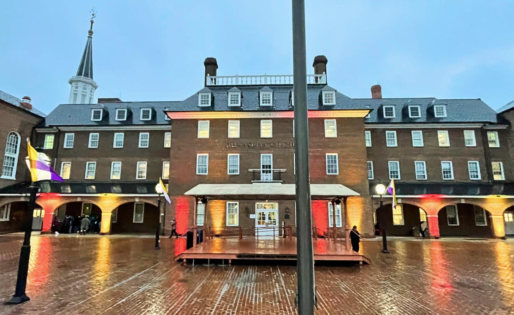 Alexandria City Hall lit up with red and gold lights in support of autism.
