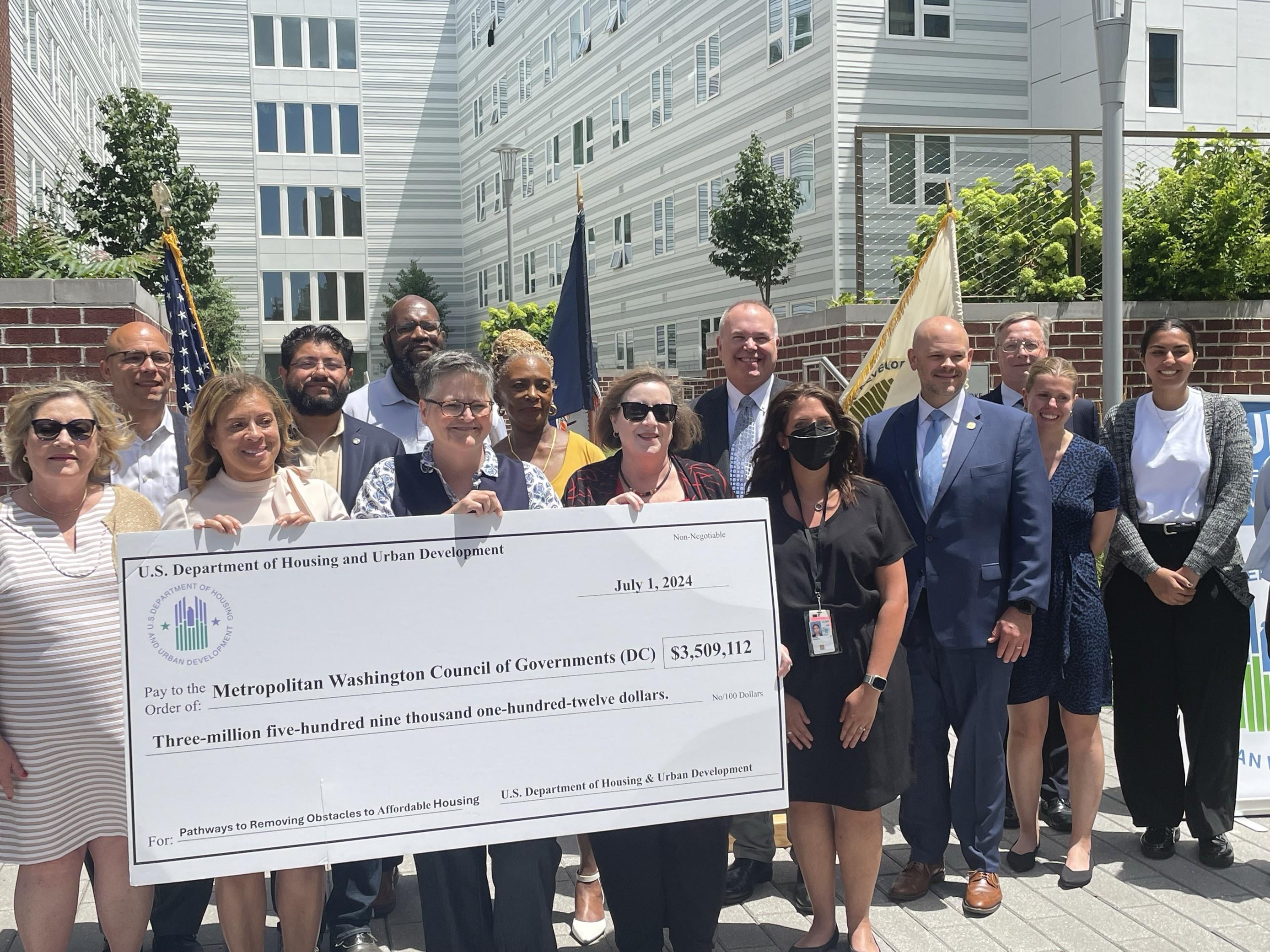 City staff, City Councilmembers, and HUD staff holding the check