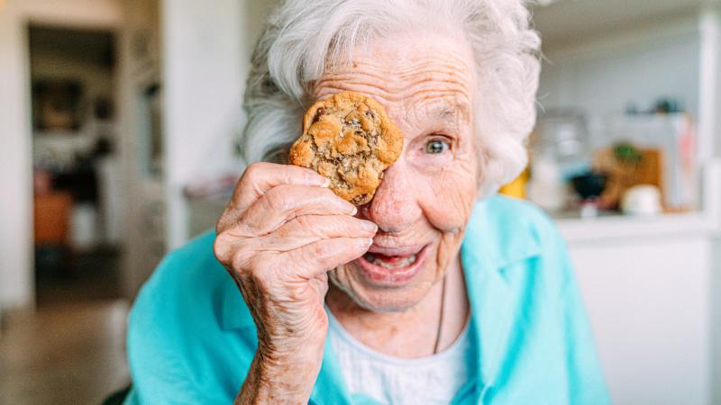 Photo of Senior lady with cookie over one eye