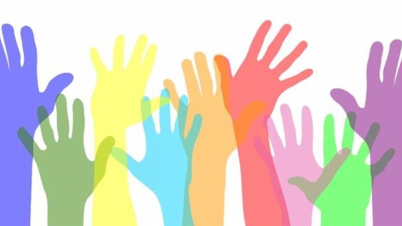 Hands raised that are different colors.