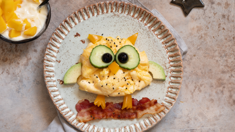 eggs and bacon shaped like an owl on a log