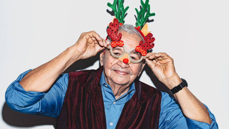 older man wearing festive christmas tree themed glasses