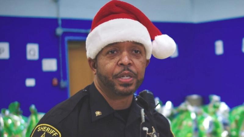 deputy in uniform wearing a red and white Santa hat