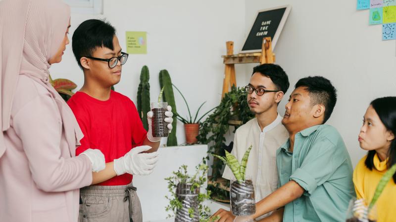 Group of Therapeutic Recreation kids sitting around the table with plants
