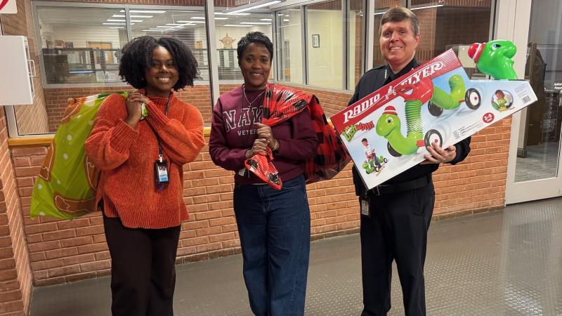 Sheriff and two civilian employees carrying children's holiday gifts