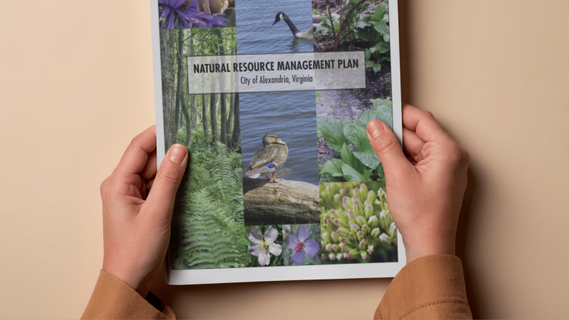Two hands holding the NRMP manual with the title Natural Resource MAnagement Plan City of Alexandria, Virginia