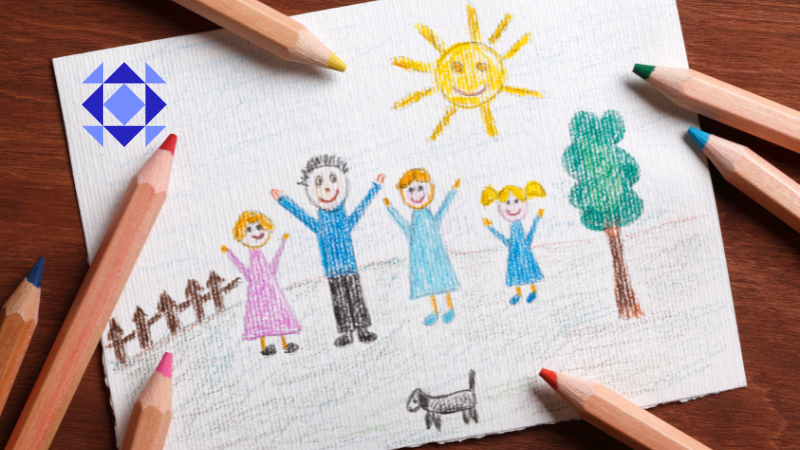Drawing of a family using colored pencils on a white paper with the sun smiling and a tree on the right and brown fence on the left and black dog in the front. There are also colored pencils scattered around the drawing on a brown table