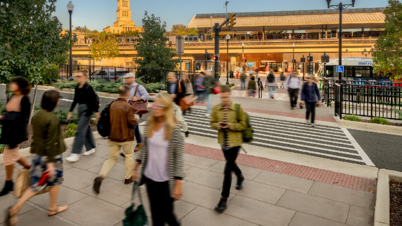 people walking in crosswalk in front of the King Street Metro Station