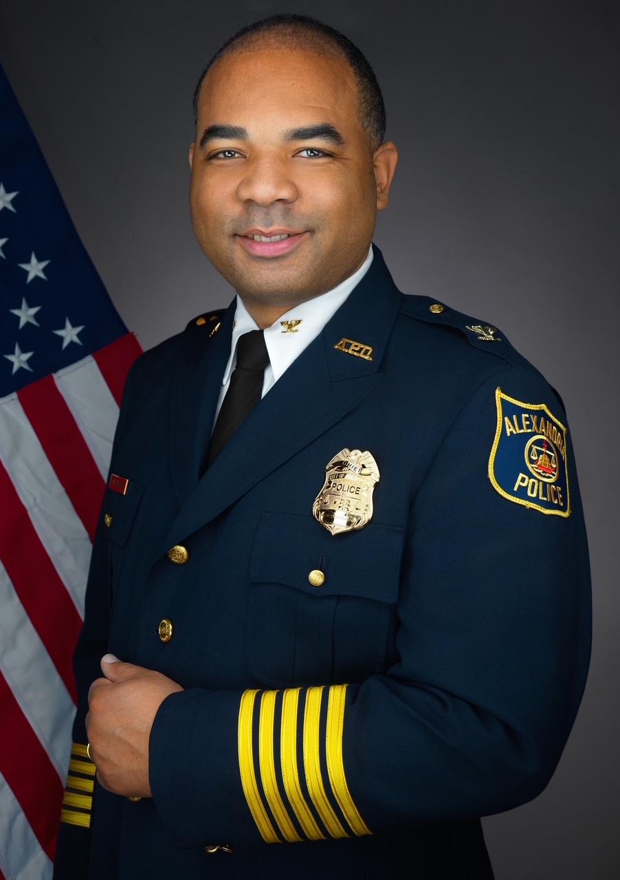 Portrait of Chief Tarrick McGuire in his dress uniform with an American flag in the background.