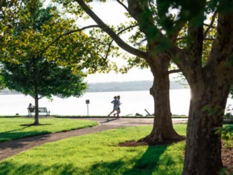Photo of two people jogging in Alexandria's Oronoco Park, next to Potomac River