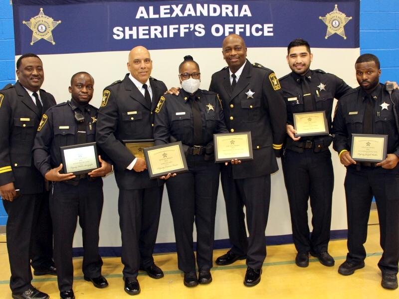 seven deputies in uniform with several holding award plaques