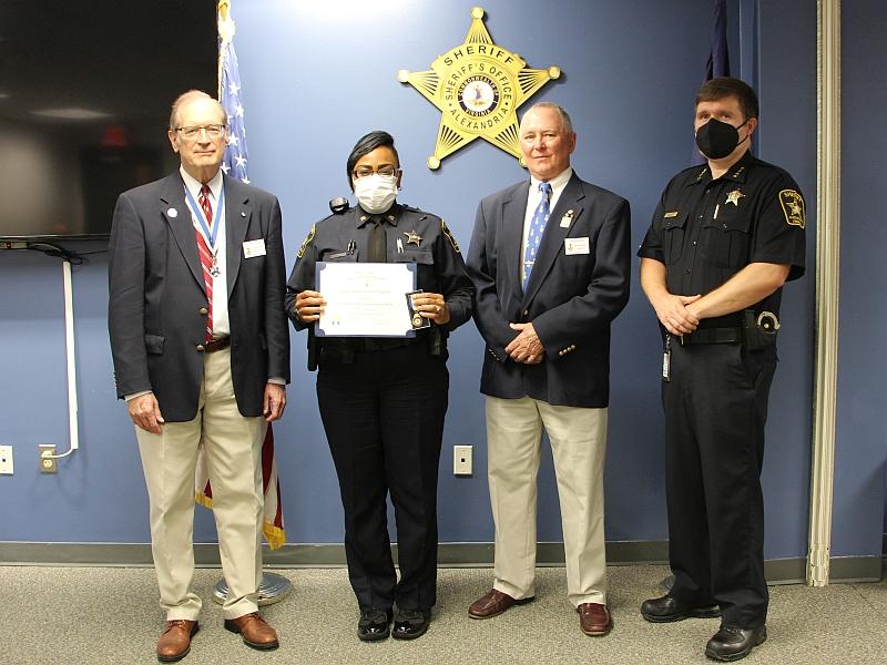 deputy holding a certificate standing with two civilians and sheriff