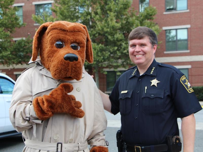 mascot in a dog costume and sheriff in uniform
