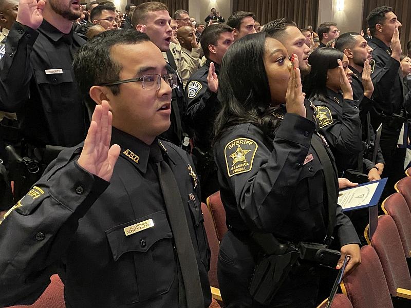 deputies in uniform holding their right hands up to take an oath
