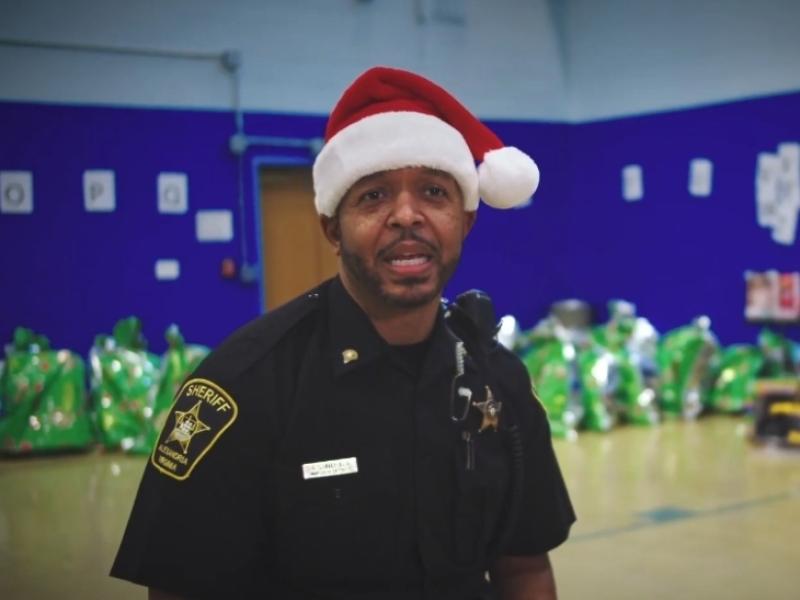 deputy in uniform wearing a red and white Santa hat