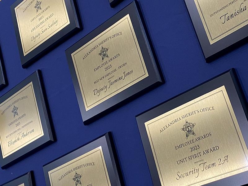 black and gold award plaques on a blue background