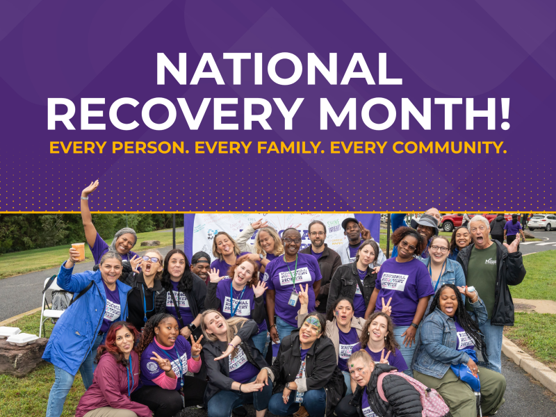 Group photo of community members celebrating National Recovery Month wearing purple shirts, beneath a purple header banner reading "National Recovery Month! Every Person. Every Family. Every Community."