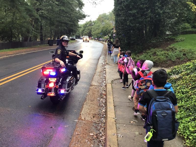 deputy on a motorcycle watching kids walking safetly