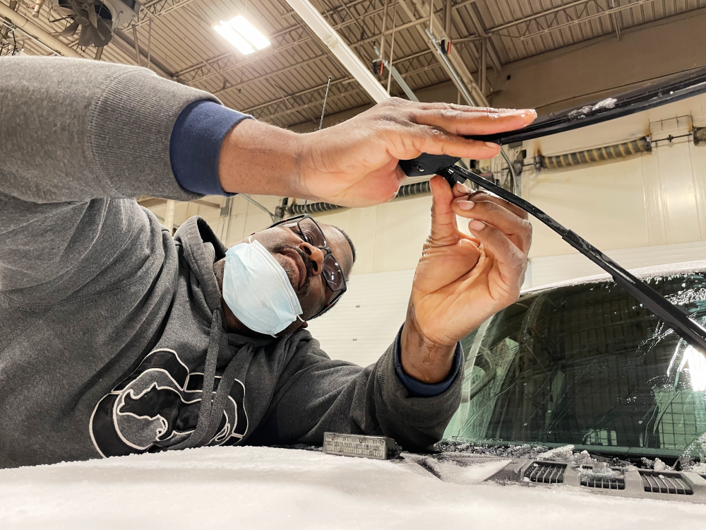 A Fleet Services technician examines a vehicle during maintenance service.
