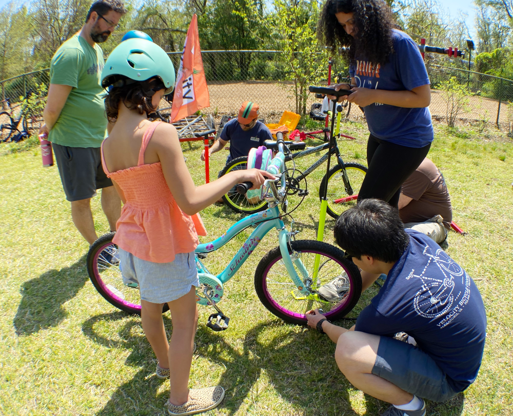 Adjusting a bicycle at the 2022 Cycling and Seedlings Earth Day event.
