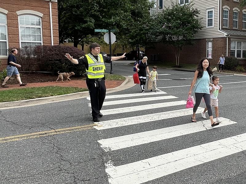 sheriff directing traffic with kids in crosswalk