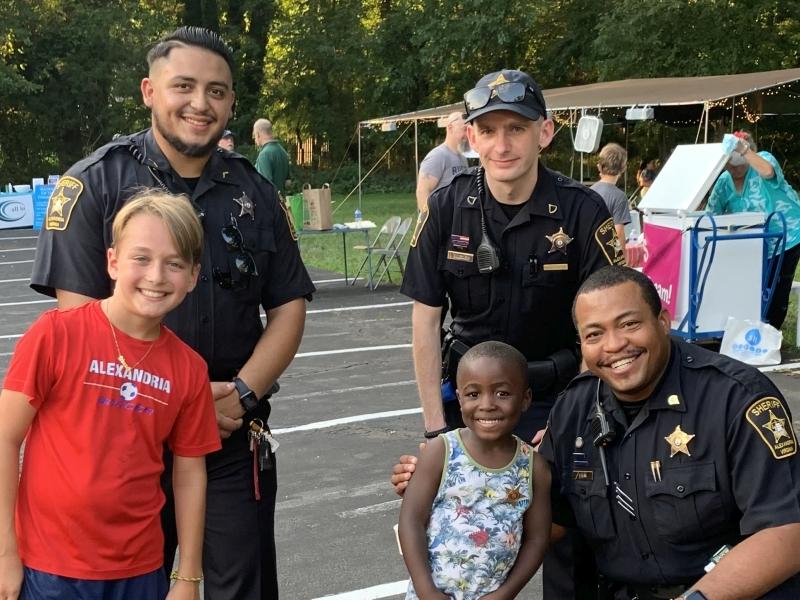 two children and three deputies all smiling