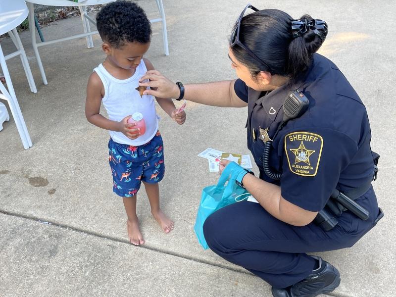 deputy giving a small child a badge sticker