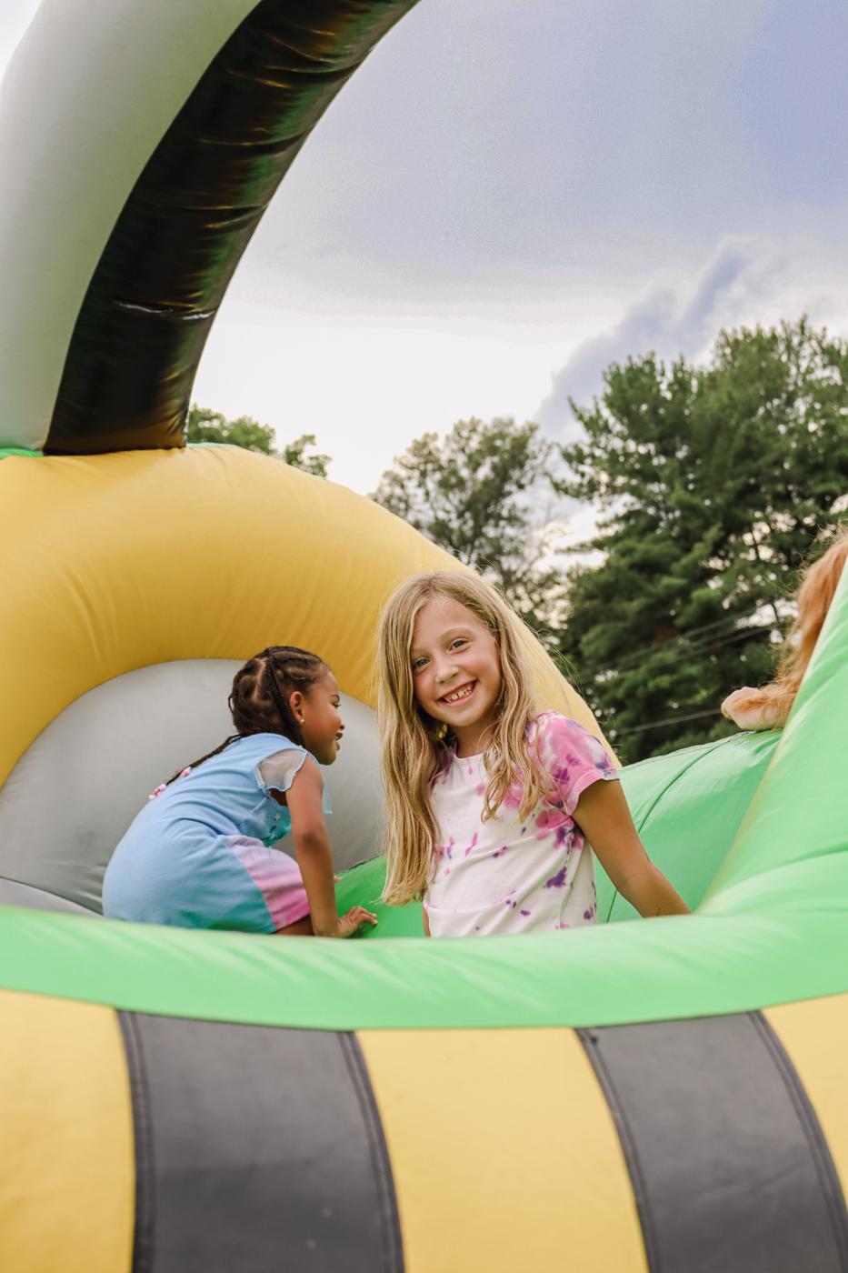 A girl smiling while on the bounce house