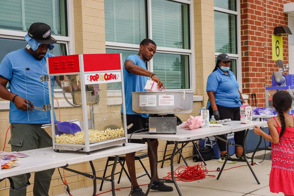 RPCA Staff serving popcorn, cotton candy, and shaved ice