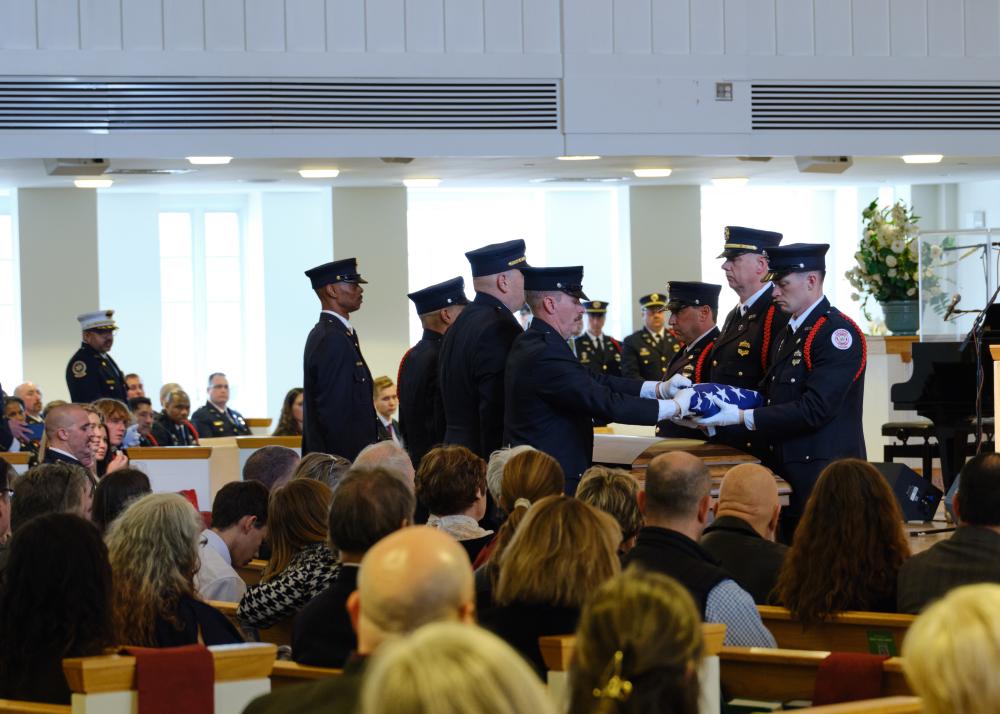 A multi-jurisdictional public safety honor guard prepare the U.S. flag for Fire/EMS Chief Corey Smedley to present to the Hricik Family during the memorial service for Deputy Chief Hricik on Saturday, March 11, 2023.
