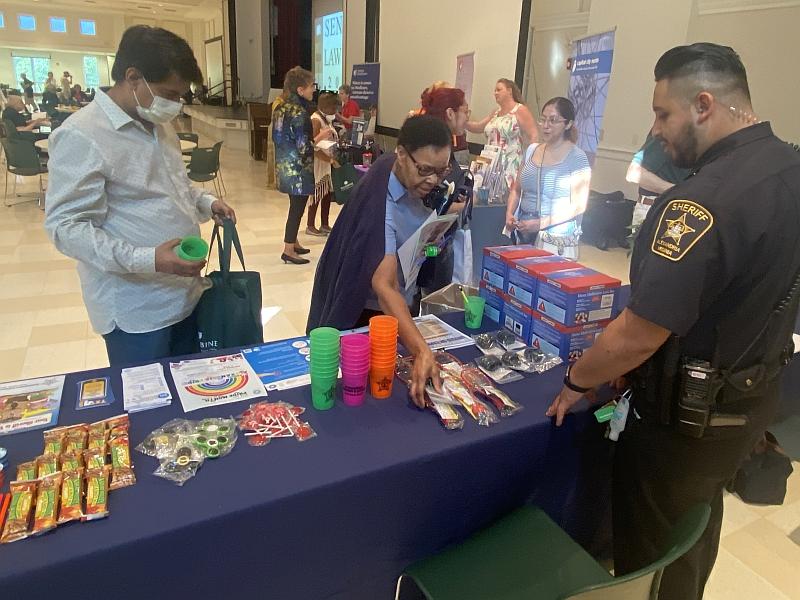 deputy at table with man and woman picking items up from table