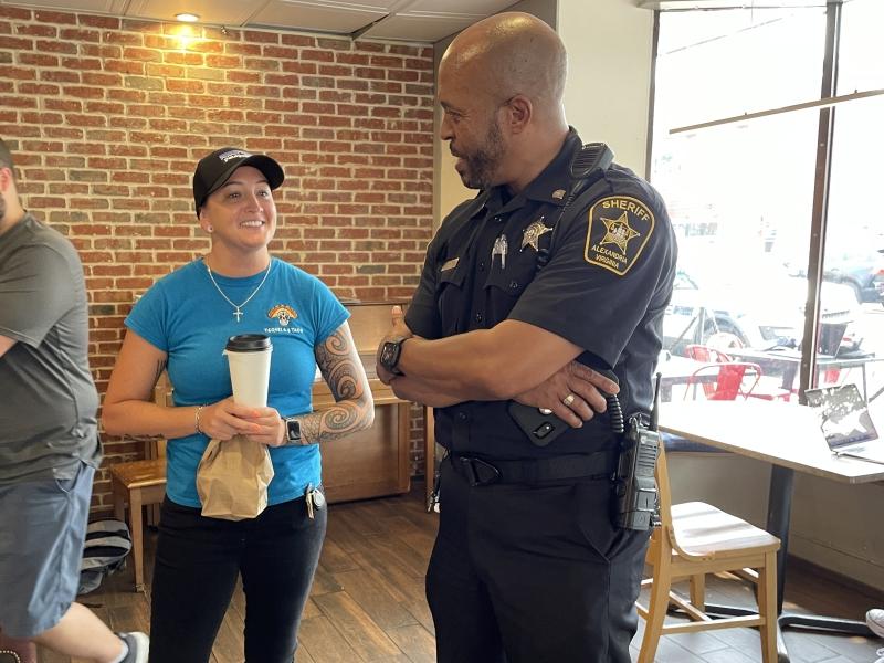 community member speaking with deputy inside coffee shop