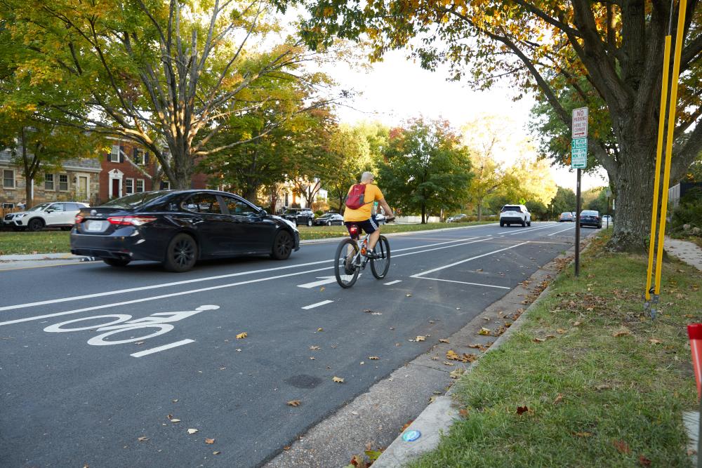 A cyclist rides in a bike lane along Commonwealth Ave.