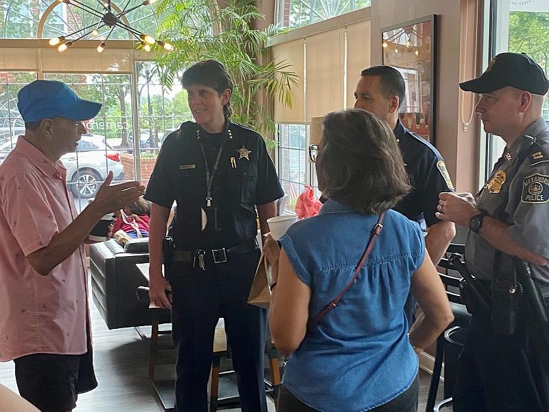 two community members speaking with three law enforcement officers inside a coffee shop