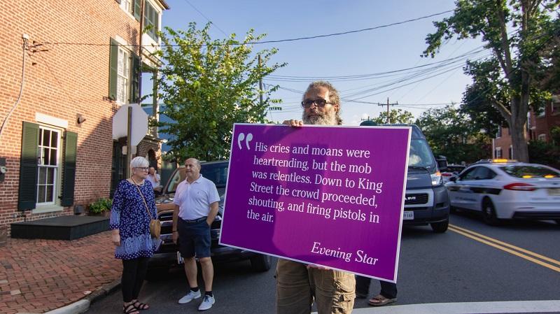 sign with quote carried in procession